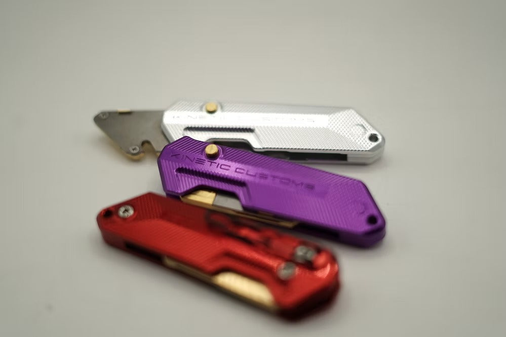 A set of Kinetic Customs Reaper BR-1 tools in various anodised finishes including Red, Purple, and Silver.