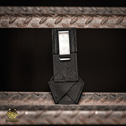  A back view of the Badger Gun Loop in black, showcasing the clip , an ideal compact tool belt accessory, designed for securing a gun or similar tool.